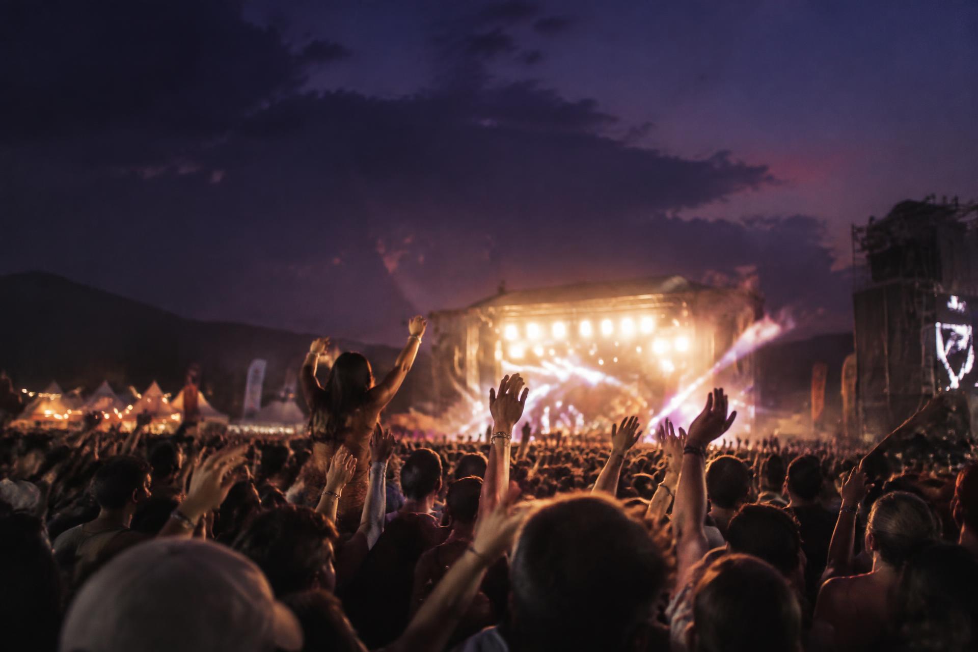 Publikum vor einer Open-Air-Bühne in der Dämmerung